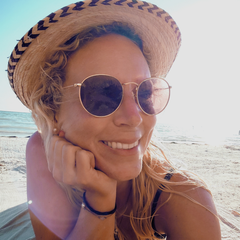 Anja Ostermann, Virtuelle Assistentin, lächelnd am Strand.